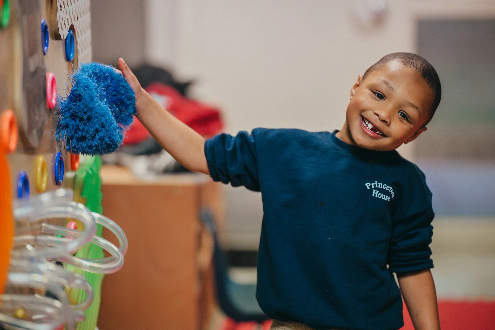 A Princeton House Charter School student explores a colorful sensory wall