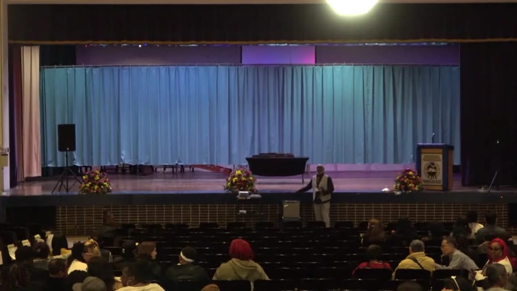 An audience gathered inside the school theater at Ray Graham Training Center High School