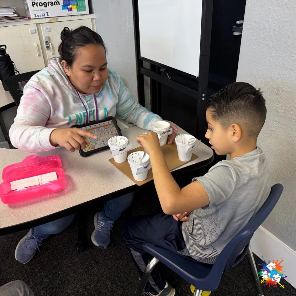 A Victory Autism Academy Phoenix teacher supports a student during a classroom activity