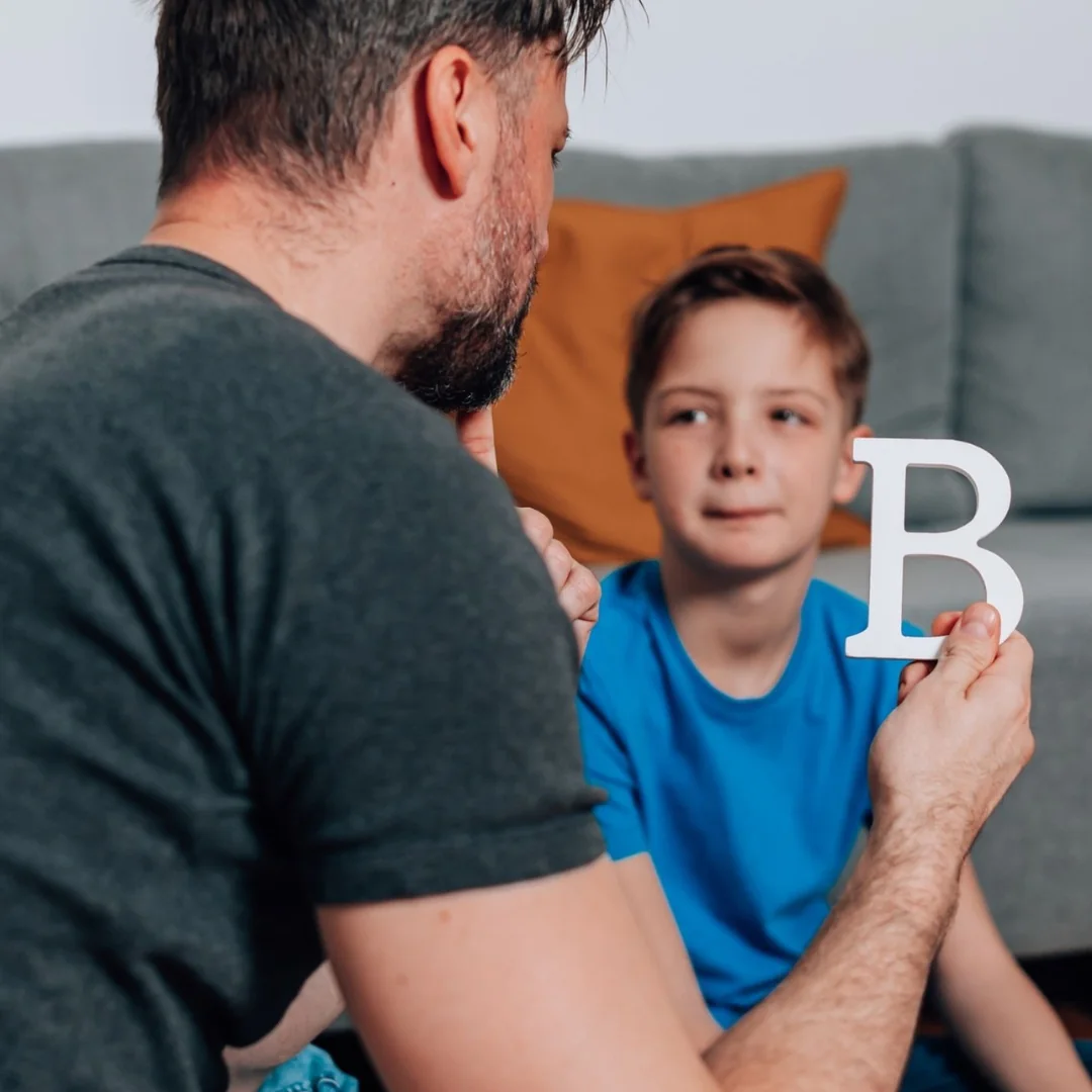 Adult supporting a child during a home activity