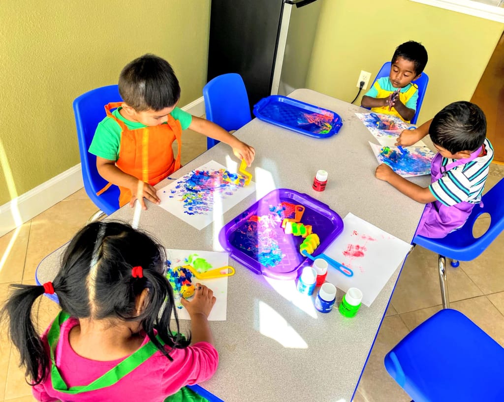 Gurukool children painting together at a classroom table