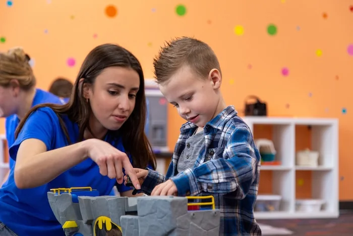 Little Leaves teacher guiding a child through a hands-on learning activity