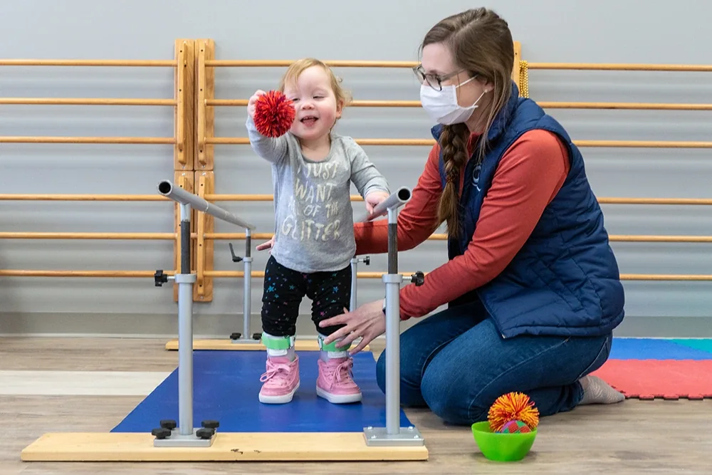 Conductive Learning Center student using supportive equipment during a movement lesson.