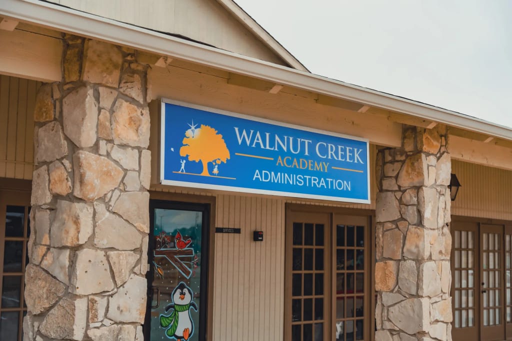 Walnut Creek Academy entrance sign and school building in Mansfield