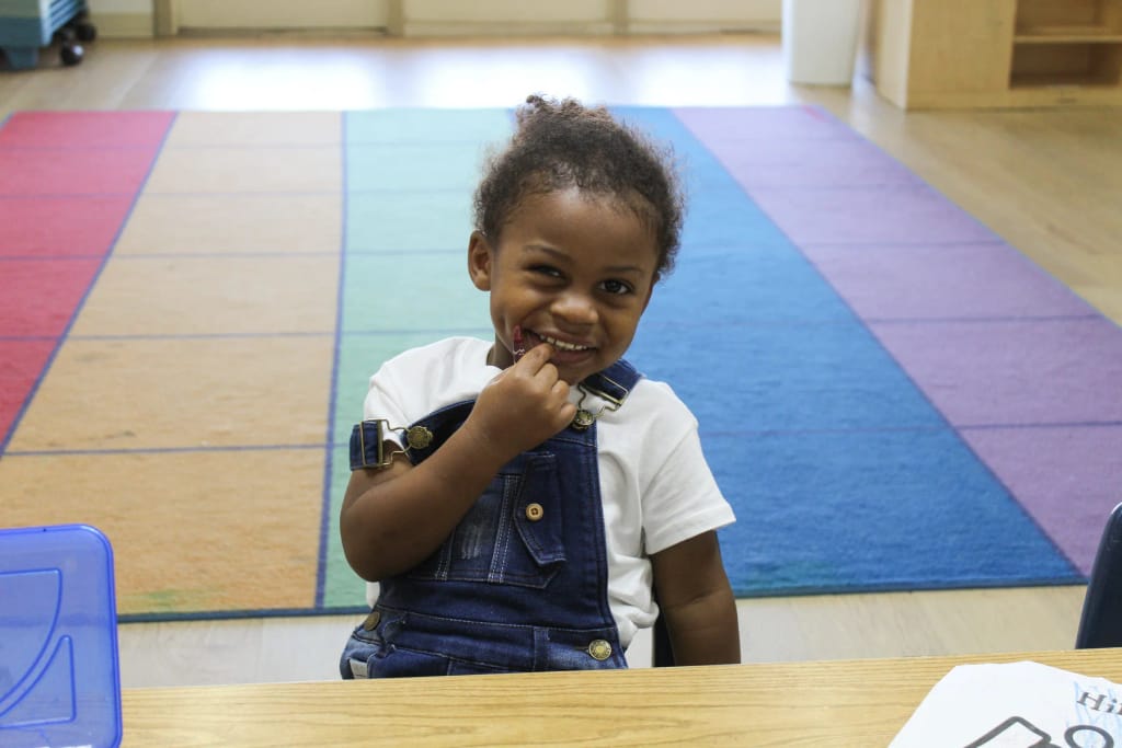 Young student exploring classroom materials at Walnut Creek Academy