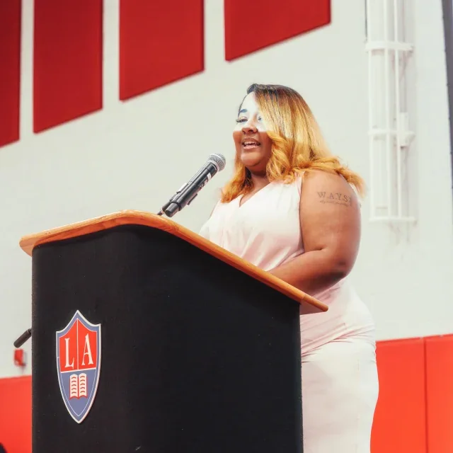 Speaker addressing the Libertas Academy school community in the gymnasium