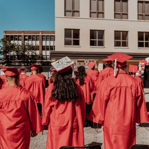 Libertas Academy students in graduation caps gathered outside the school