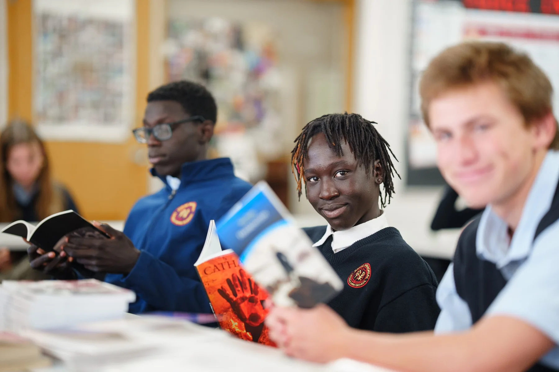 Judge Memorial Catholic High School students seated with books in a classroom.
