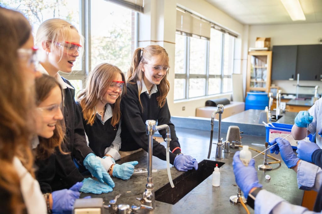 Judge Memorial Catholic High School students and teacher working in a science lab.