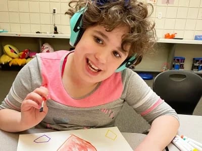 Carmen B. Pingree Autism Center student drawing shapes at a classroom table.