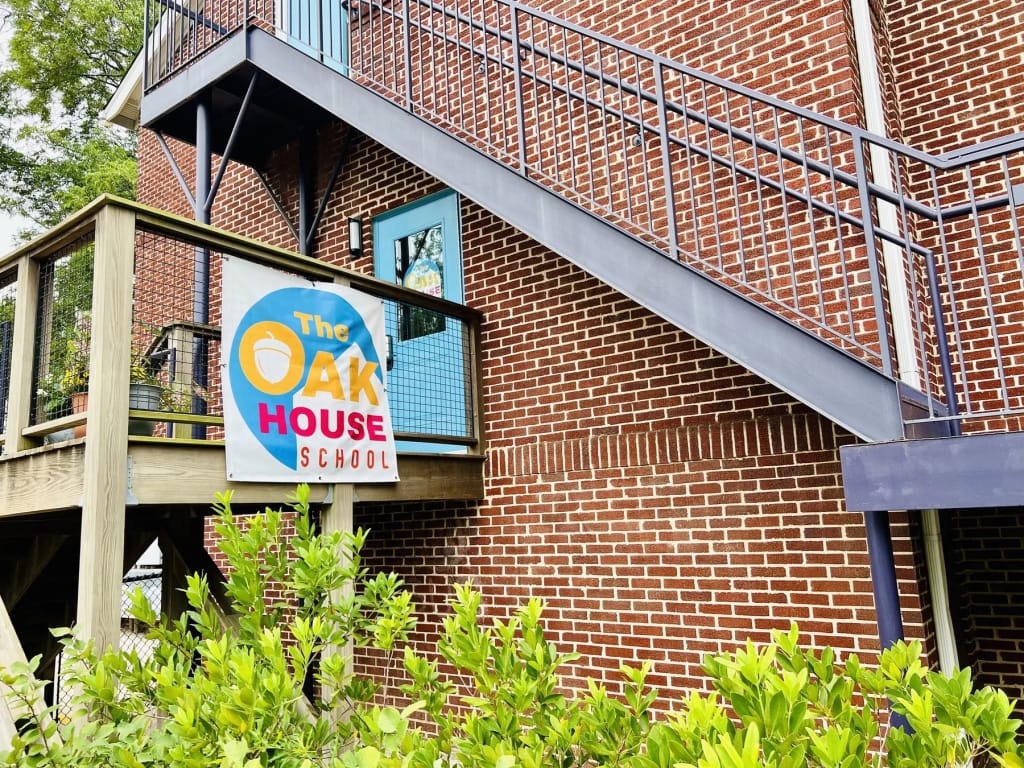 The school building and outdoor sign at The Oak House School