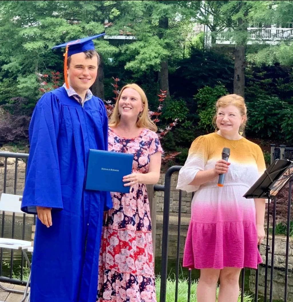 A graduate celebrating with school staff at Connections School of Atlanta