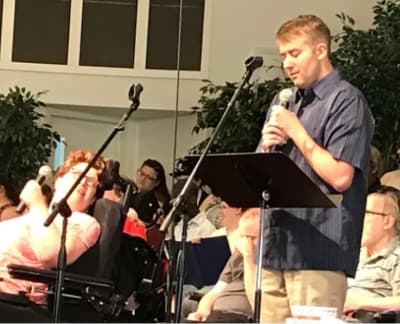 Adult Enrichment participant speaking during a musical performance