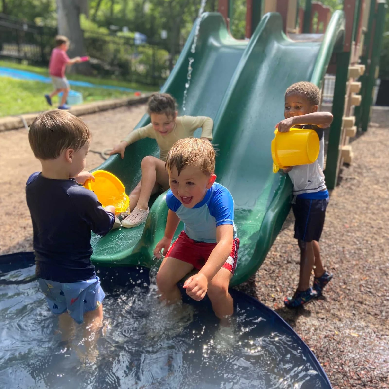 Children playing on a water slide during camp at Community School in St. Louis