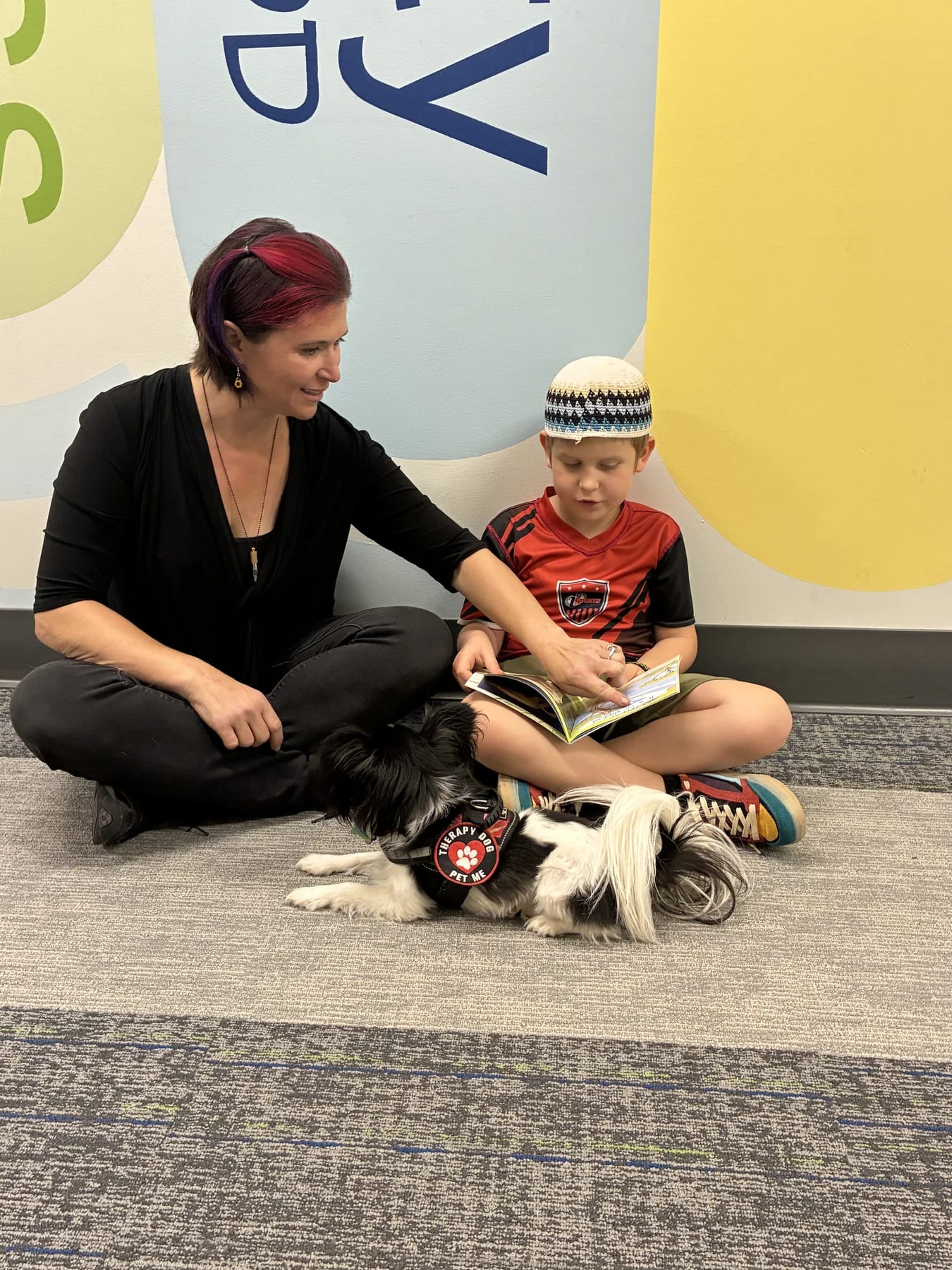 Teacher reading with a Keshet student in a classroom