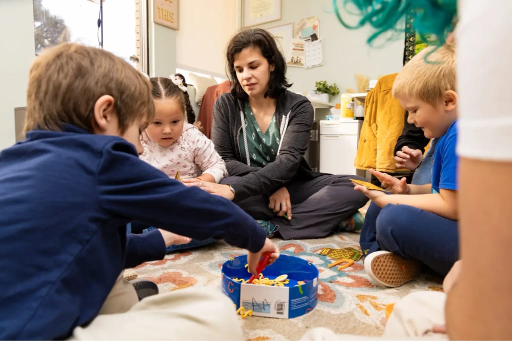 Children and adults gathered for a group activity at Woven Care Central West