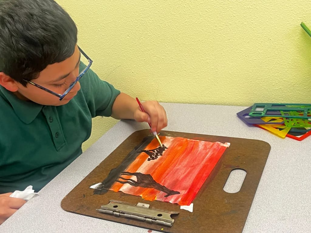 A Pegasus School student paints during an art class