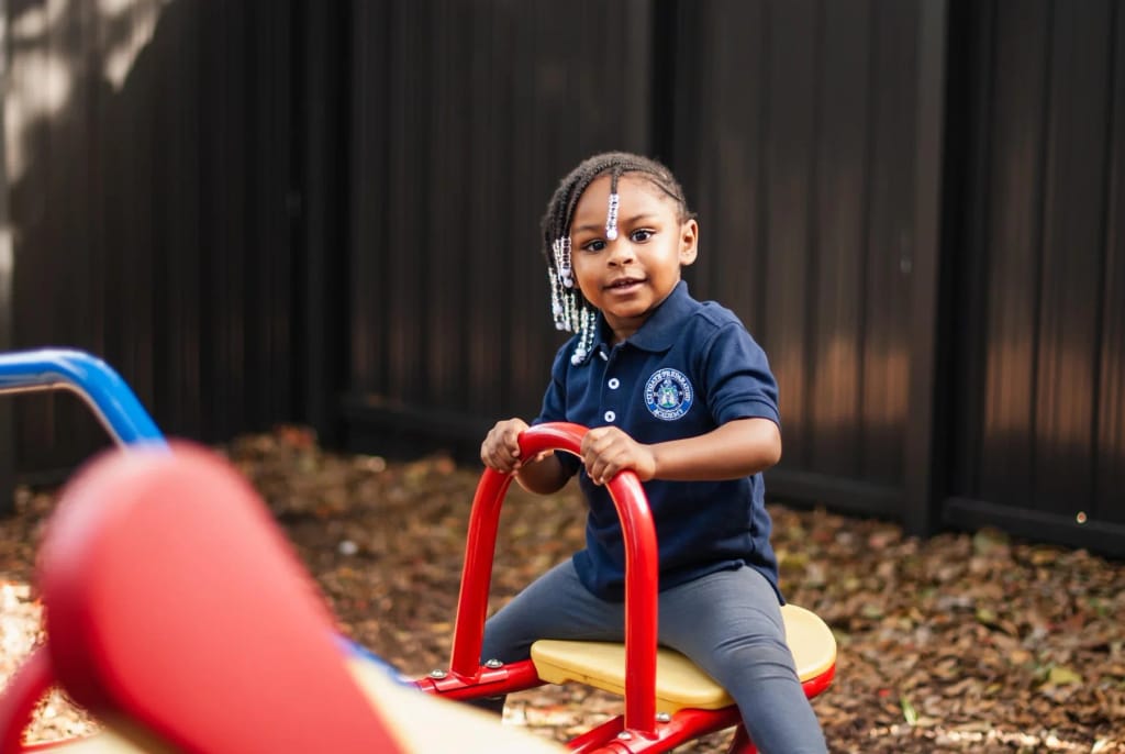 A student uses outdoor playground equipment at City Innovation School