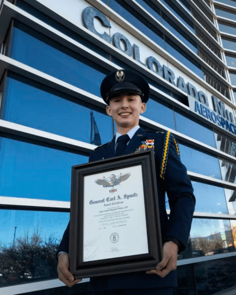 Colorado Military Academy student holding an award outside the Colorado Springs campus.