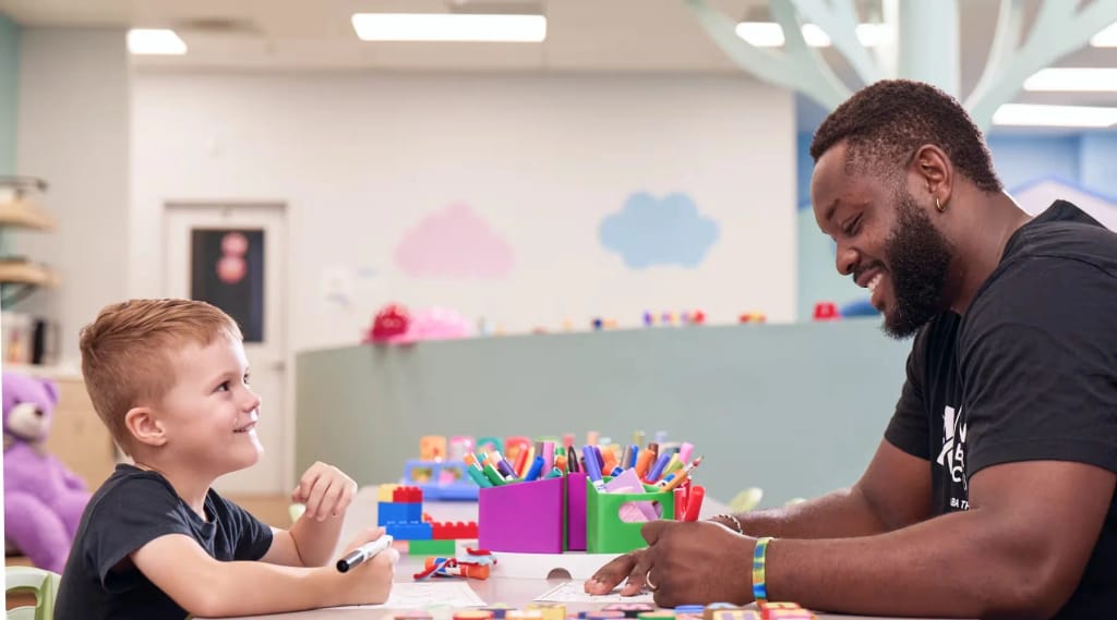 Therapist and child playing together at a table