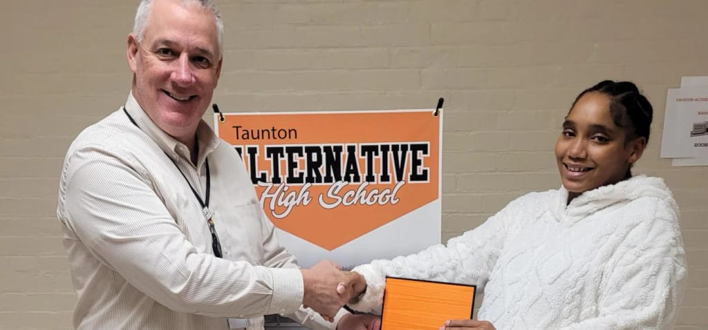 Taunton Alternative High School staff member and student celebrate at the school.