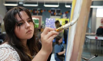 Academy of Arts and Academics student painting in art class