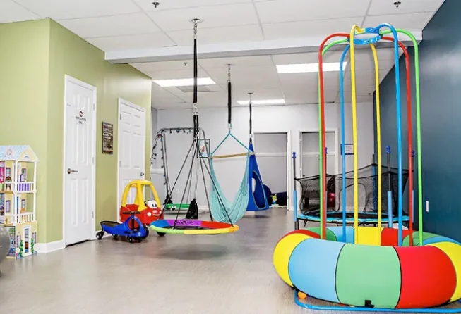 Indoor Step Forward ABA therapy activity space with play and movement equipment.