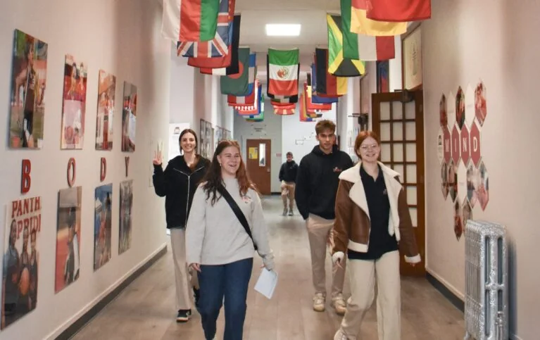 Menaul School students and a staff member walking through a school hallway.