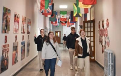 Menaul School students and a staff member walking through a school hallway.