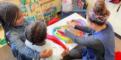 Mullings Academy of Hollywood in Hollywood: children and an adult participating in a classroom art activity.