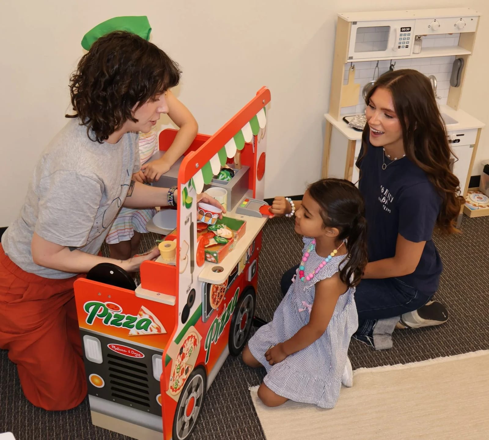 Clinician and children engaged in a hands-on indoor play activity at Ability ABA.