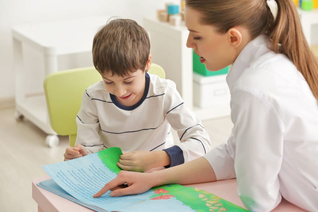 Child reading with clinician