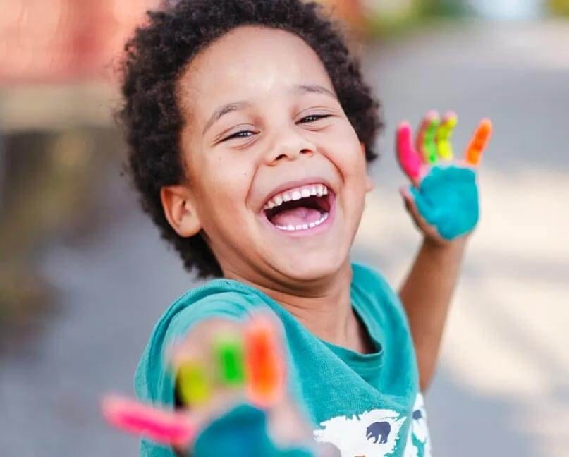 Smiling child with painted hands