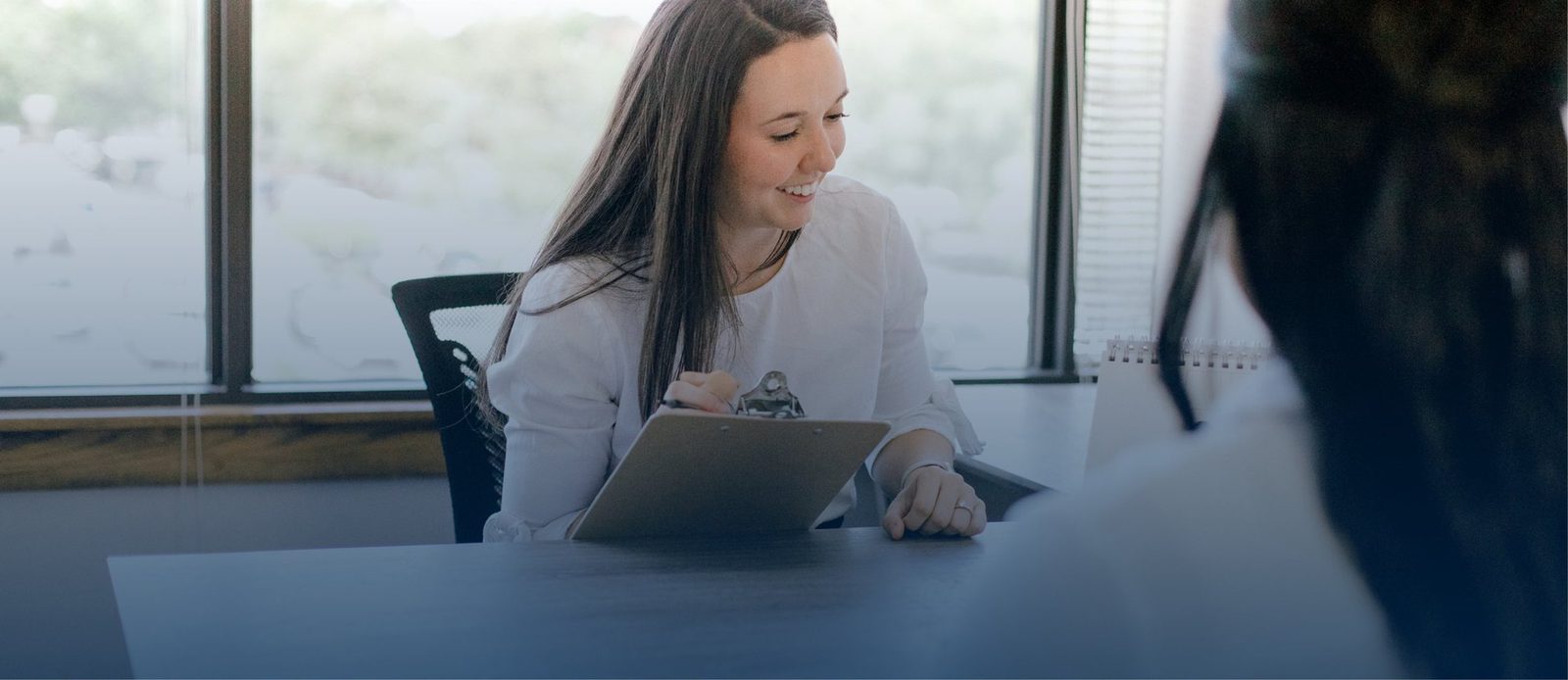 Clinician meeting with a client at a desk