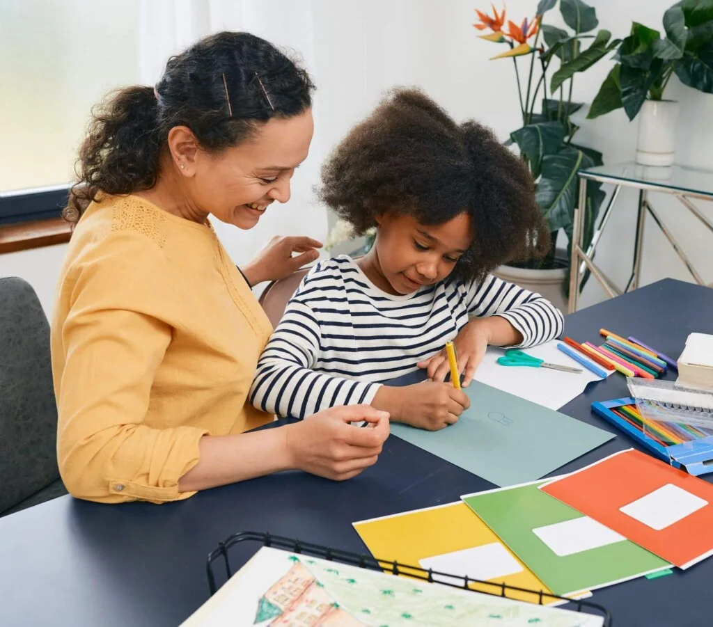 Adult supporting a child during a tabletop activity