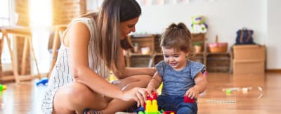 Adult and young child playing together with developmental toys