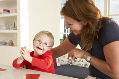 Speech therapist working with a child at a table