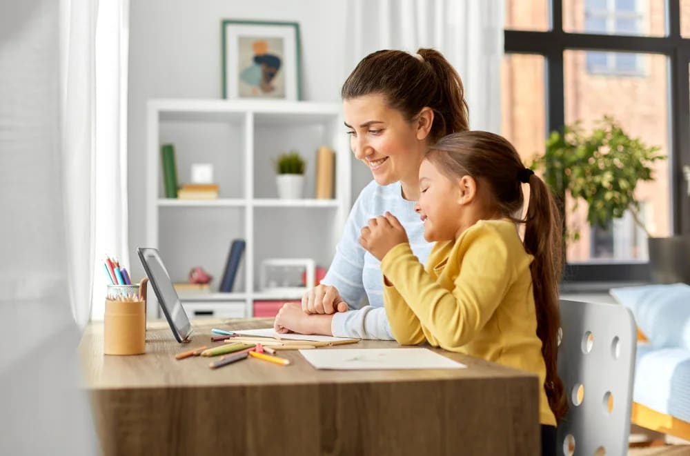 Mother and daughter looking at a tablet together at a desk