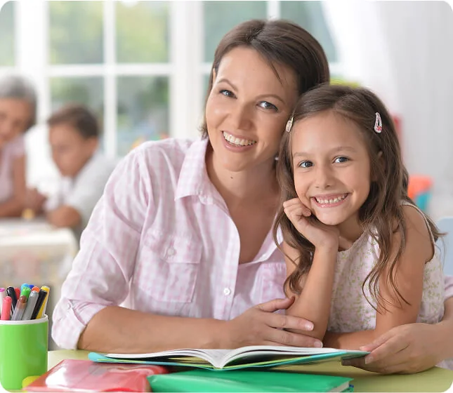 Adult and child reading together at a table