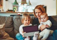 Parent and two young children using a tablet at home
