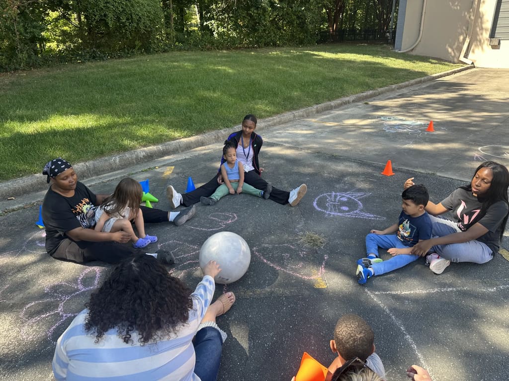 Therapists and children sitting in a circle during outdoor session