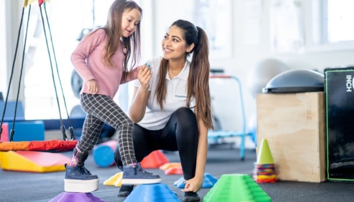Therapist supporting a child during a balance activity