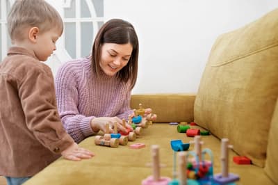 Caregiver and child playing together with wooden toys
