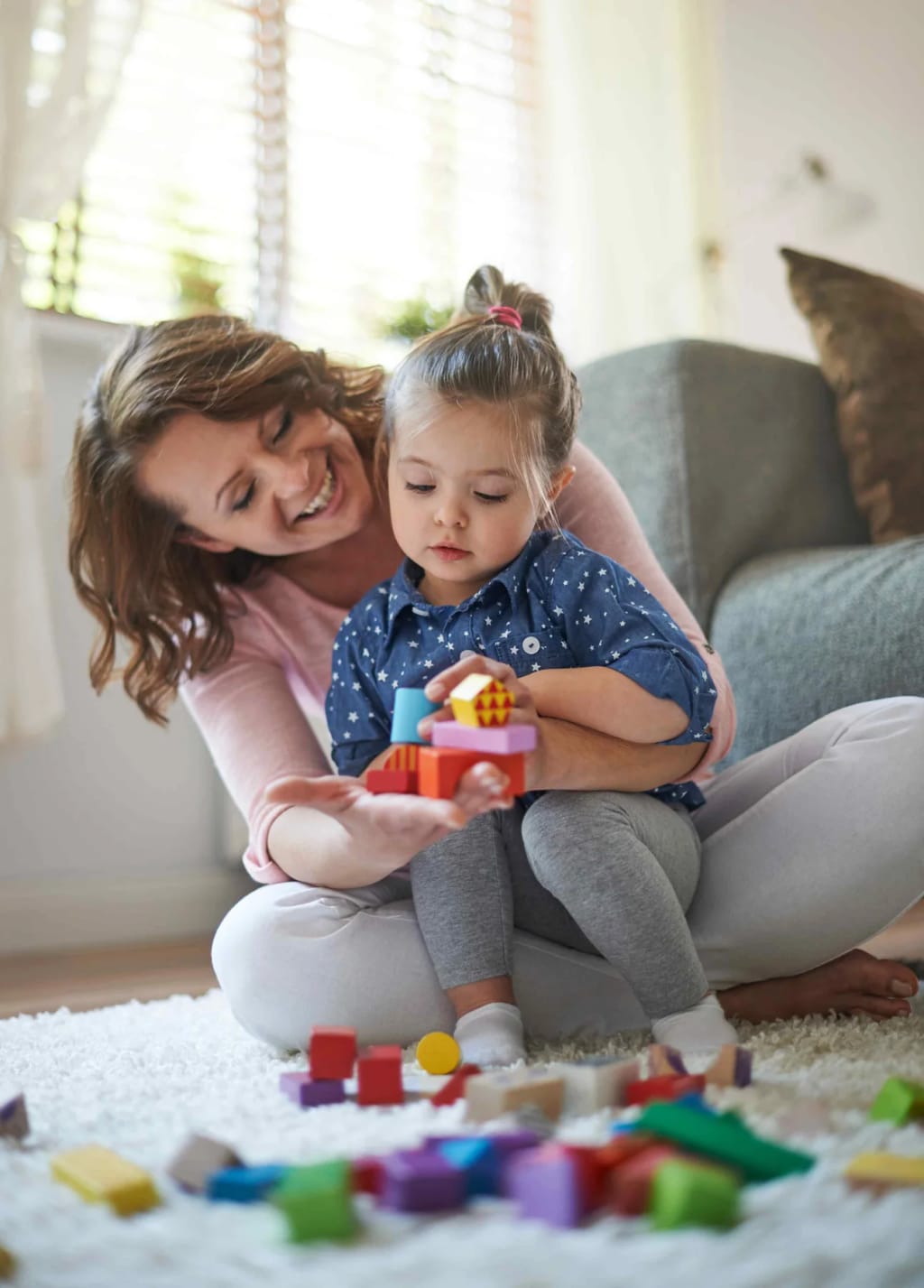 Adult and young child playing with colorful blocks