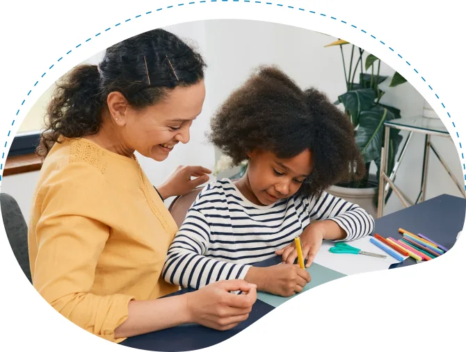 Adult supporting a child during a drawing activity