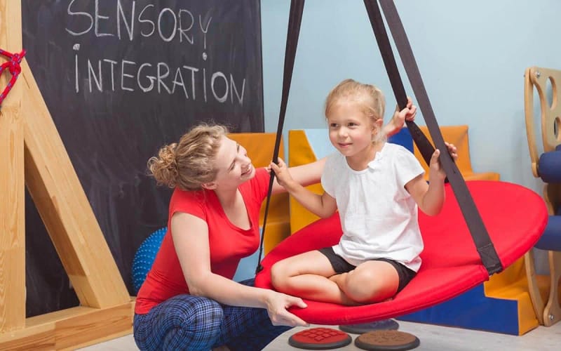Therapist supporting a child during a sensory activity