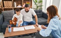 Parent and child meeting with a therapist in a home setting